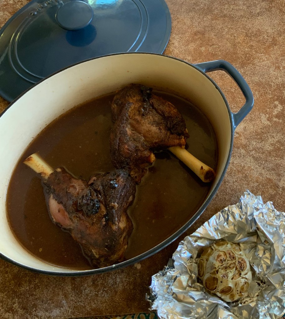 Lamb shanks and roadted head of garlic clives. Ready for braising